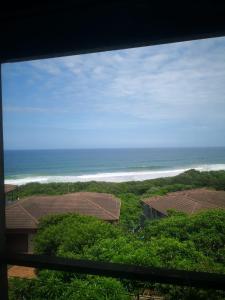 a view of the ocean from a house at Blissful Beachfront Apartment - 11 Sovereign sands in KwaDukuza
