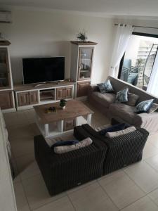 a living room with couches and a flat screen tv at Blissful Beachfront Apartment - 11 Sovereign sands in KwaDukuza
