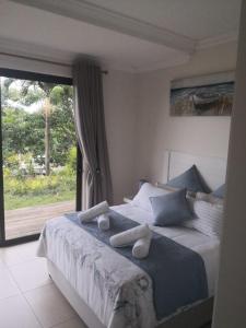 1 dormitorio con 1 cama con toallas en Blissful Beachfront Apartment - 11 Sovereign sands en KwaDukuza