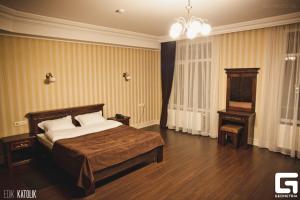 een slaapkamer met een bed, een tafel en een kroonluchter bij Georg Park Hotel in Tarashany