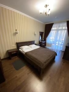 a bedroom with a bed and a chandelier at Georg Park Hotel in Tarashany