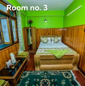 a bedroom with a bed with a green wall at Tharbaling HomeStay in Darjeeling