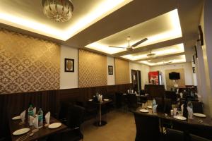 a dining room with tables and chairs and a chandelier at HOTEL SURYA INTERNATIONAL in New Delhi