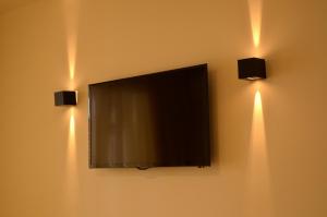 a flat screen tv on a wall with two lights at Apartment Suite Theater in Split