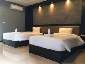 - 2 lits dans une chambre d'hôtel avec des draps blancs dans l'établissement น้ำเค็มอินน์ Namkhem Inn, à Phangnga