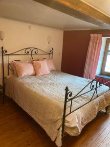 a bedroom with a large bed with pink pillows at En mode Pause in Dinant