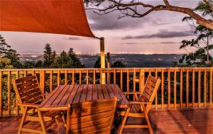 een houten tafel en stoelen op een houten terras bij Tamborine Mountain Bed and Breakfast in Mount Tamborine