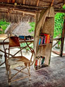 a chair sitting in a room with a book shelf at Your Zanzibar Place in Paje