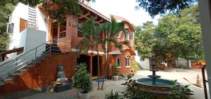 un bâtiment avec une fontaine devant lui dans l'établissement GG Resorts, à Auroville