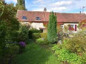 une maison ancienne avec un jardin en face dans l'établissement Charming Holiday Home, à Mézy-Moulins