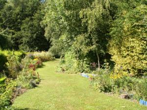 um jardim com muitas plantas e árvores em Charming Holiday Home em Mézy-Moulins