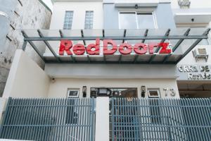 a red door sign on the front of a building at RedDoorz Plus @ Torre De Manuel Residences 1 in Manila