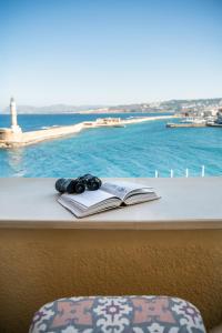a book and headphones sitting on a ledge with the ocean at San Salvatore Monastery in Chania Town