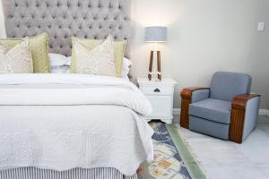um quarto com uma cama e uma cadeira azul em Burkleigh House em Joanesburgo