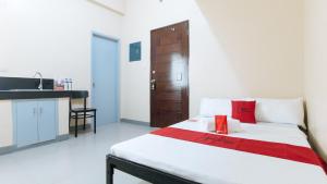 マニラにあるRedDoorz Plus @ Torre De Manuel Residences 1のベッドルーム1室(赤いボックス付きのベッド1台付)