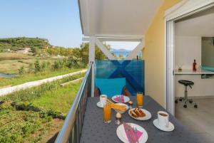 a balcony with a table with food on it at Studio Timotheos in Marathias
