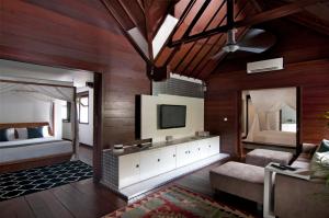 a bedroom with two beds and a television in it at 5BR Villa Sabtu - Minggu Villas Seminyak in Seminyak