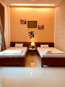 una habitación con dos camas y una mesa con lámpara en Biệt Thự Villa Hai Nam -Vung Tau-G8 Bau Sen 08, en Vung Tau