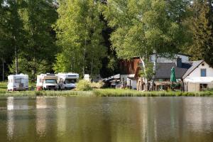 Um par de autocaravanas estacionadas ao lado de um lago. em Wiesner's Teichwirtschaft em Scheibenberg