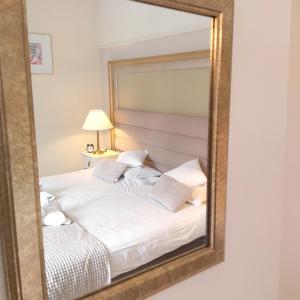 a mirror reflecting a bed in a bedroom at Villa Lessing in Polanica-Zdrój