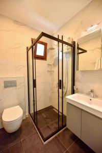 a bathroom with a shower and a toilet and a sink at Kordon YALI Suites in Fethiye