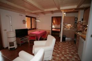 sala de estar con sofá, mesa y cocina en Residence Anny, en Canazei