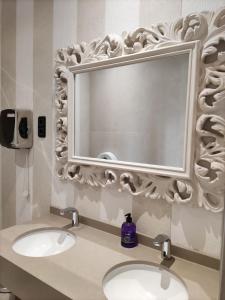 a bathroom with two sinks and a large mirror at Hotel Ciudad de Navalcarnero in Navalcarnero