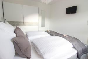 1 Schlafzimmer mit 2 Betten mit Kissen und einem TV in der Unterkunft Appartements am Bodetal in Thale