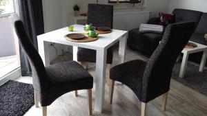 ブラウンラーゲにあるApartments Gosch Braunlageのテーブル(椅子2脚付)、白いテーブル(食器付)