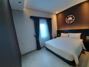 Postel nebo postele na pokoji v ubytování Americano Hotel Syariah Yogyakarta