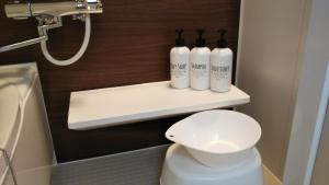 a bathroom with a toilet and three bottles on a shelf at KAINOSATO in Fujikawaguchiko