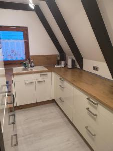 eine Küche mit weißen Schränken und einem Fenster in der Unterkunft Ferienhaus Fynnhütte in Schwarzenborn