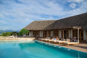 a resort with a swimming pool and people sitting on the patio at Manyara's Secret in Mto wa Mbu