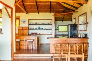 a kitchen with a bar with stools in it at Tree House Villa in Praia do Tofo
