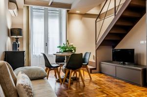 a living room with a couch and a table with chairs at Ferrini Home - Residence 150 in Catania