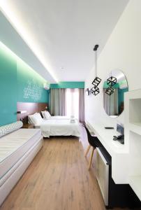 a bedroom with two beds and a desk at Rotonda Hotel in Thessaloniki