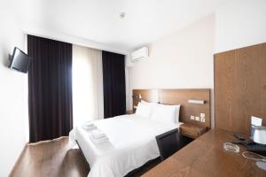 a hotel room with a bed and a desk at Rotonda Hotel in Thessaloniki