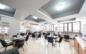 a dining room with tables and chairs and windows at Rotonda Hotel in Thessaloniki
