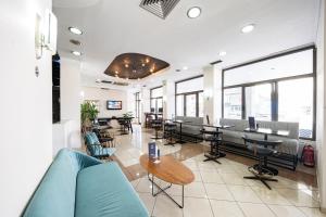 a large room with tables and chairs and windows at Rotonda Hotel in Thessaloniki