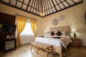 ein Schlafzimmer mit großem Bett und Fernseher in der Unterkunft New Sunari Lovina Beach Resort in Lovina