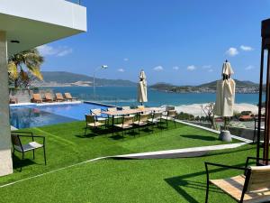a pool with chairs and a table with umbrellas at Harbor View Villa in Nha Trang