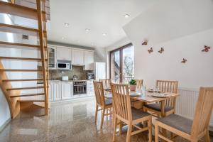 a kitchen and dining room with a table and chairs at Rezydencja Wind Rose - luxury ApartHotel Gdansk in Gdańsk