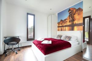 a bedroom with a red bed and a chair at Rezydencja Wind Rose Luxury ApartHotel Gdańsk - Prywatne SPA in Gdańsk