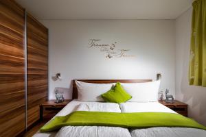 a bedroom with a bed with a green blanket at Appartement Mountainview in Sankt Gallenkirch