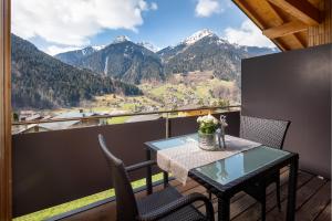 a table and chairs on a balcony with mountains at Appartement Mountainview in Sankt Gallenkirch
