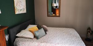 a bedroom with a bed with pillows on it at La Cour Du Puits Chambre Matcha in Cormeilles