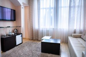 a living room with a couch and a tv at Derzhava Hotel in Penza