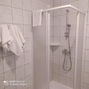 埃格爾的住宿－Bacchus Panzió，浴室提供白色毛巾和淋浴。