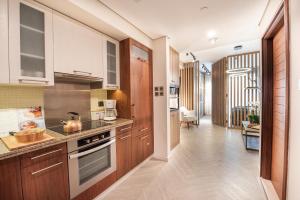 cocina con armarios de madera y horno con fogones en Nasma Luxury Stays - Boulevard Central Tower, en Dubái
