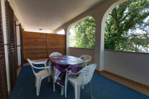 a dining room with a table and chairs and two windows at Apartments Draga in Vantačići